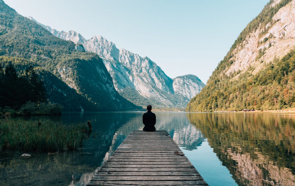 Man meditating by a lake