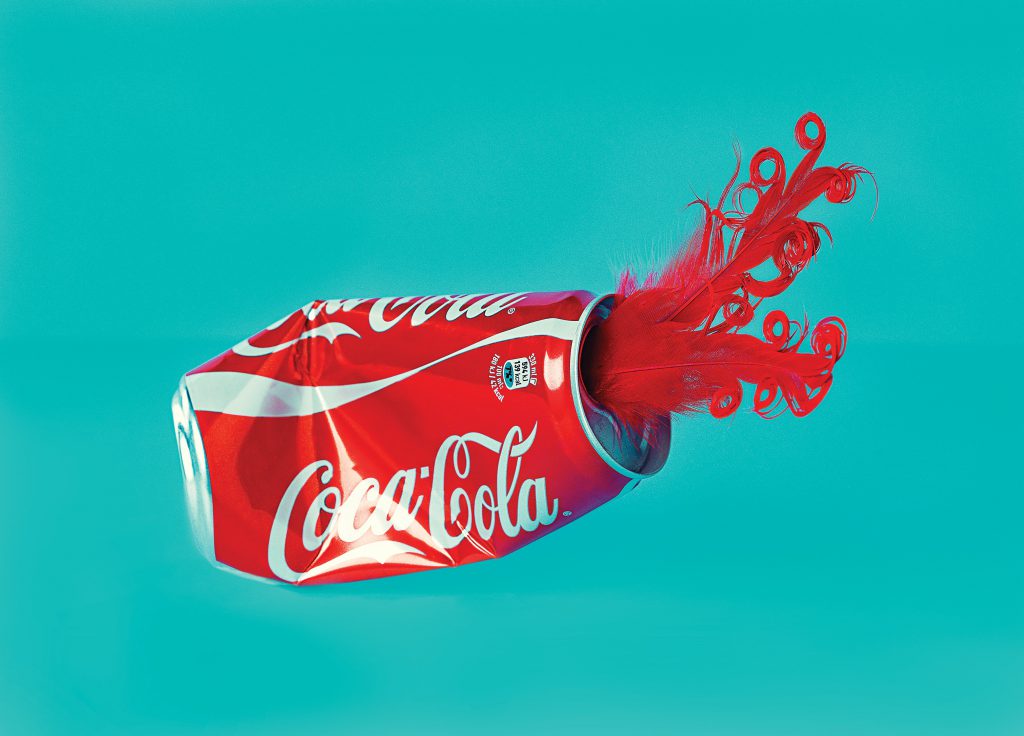 Red Coca-Cola can spilling red ink